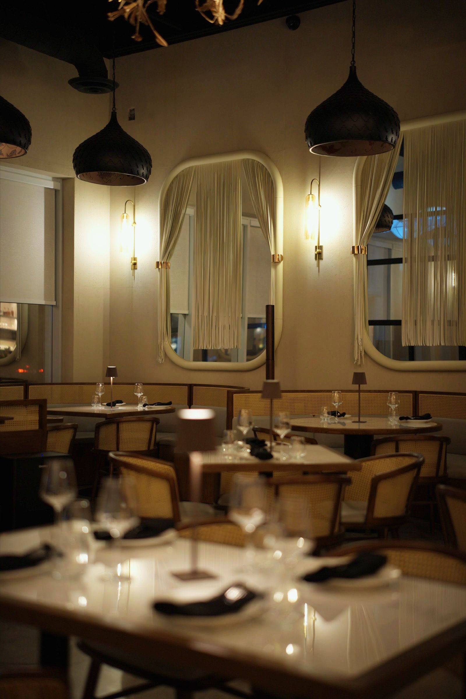 The dining room with its arched mirrors and warm wall lights